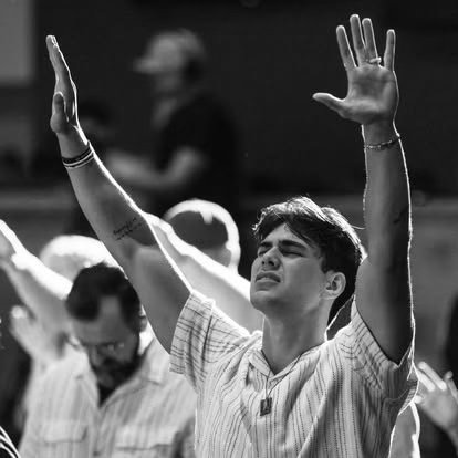 A member worshiping with hands raised