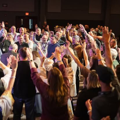 Congregation worshiping together, hands raised